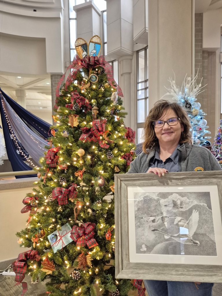 Jennifer Jackson, Regional Communication Manager, holding a gift to the Friends of EFNA of an Edson Fichter print.